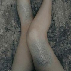 the legs and ankles of a woman with tattoos on her body are shown from above