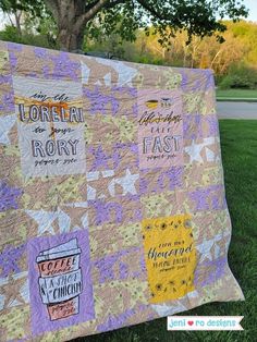 a quilt is on the grass in front of a tree