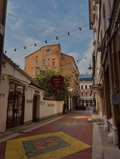 an empty street with buildings and string lights