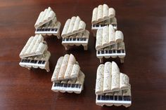six miniature piano keys sitting on top of a wooden table next to eachother