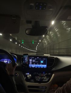 the interior of a car is lit up with green and blue lights as it drives through a tunnel