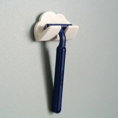 a toothbrush is hanging on the wall with a toothpaste holder attached to it