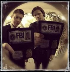 two men standing next to each other in front of a circular window with the words fib on it