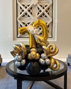 a table that has some balloons on it with the number one in gold and silver