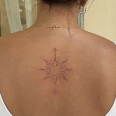 the back of a woman's shoulder with a sun tattoo on her upper arm
