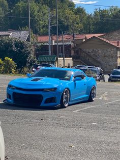 a blue sports car parked in a parking lot