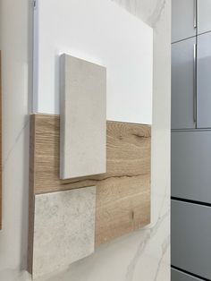 a kitchen with white cabinets and marble counter tops on the wall next to a gray refrigerator