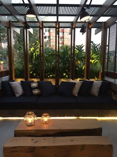 a living room filled with lots of furniture and lit candles on top of the coffee table