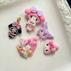 there are many different key chains on the tray together, including hello kitty and panda