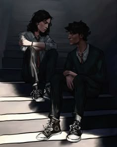two young men sitting on steps in the dark