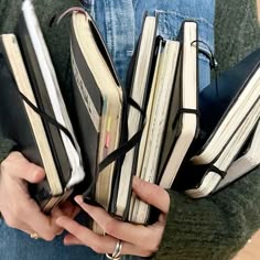 a person holding several books in their hands