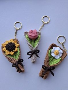 three crocheted keychains with flowers on them sitting next to each other
