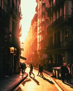 people are walking down the street in an old city at sundown or sunrise time