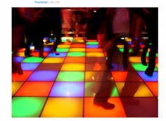 many people are dancing on a brightly lit dance floor