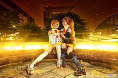 two young women sitting on top of a bench next to each other in front of a building