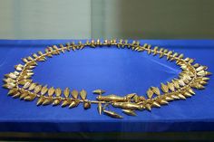 a gold necklace is displayed on a blue table