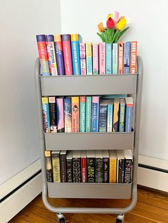 there is a book cart with many books on it and a flower in the middle