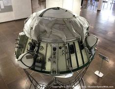 the space shuttle is covered with plastic and sits on display in an exhibit room at the national air and space museum