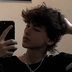 a young man is holding up his cell phone