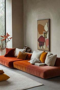a living room filled with lots of furniture next to a large painting on the wall