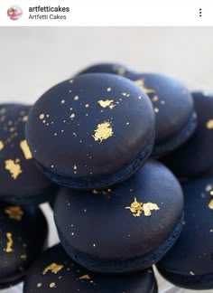 some black and gold decorated macaroons are stacked on top of each other