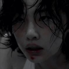 a close up of a person's face with blood on her cheek and hair