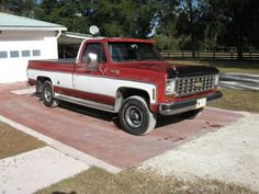 a red and white truck parked in front of a house