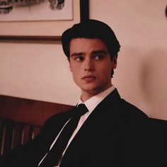 a man in a suit and tie sitting on a bench