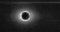 a black hole in the sky with light coming from it's center and stars around it