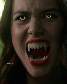 a woman with her mouth open and fangs out