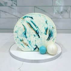 a marble plate with two balls on the side next to it and a tile wall behind it