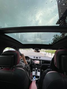 two people in the driver's seat of a car looking at something on the screen