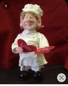 a figurine holding a heart shaped frisbee