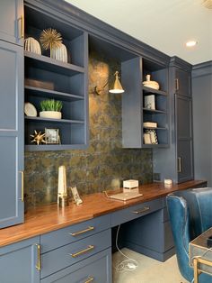a kitchen with blue cabinets and wooden counter tops, gold accents on the backsplash