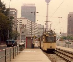 a yellow train traveling down tracks next to tall buildings