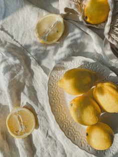 three lemons are on a plate with one cut in half