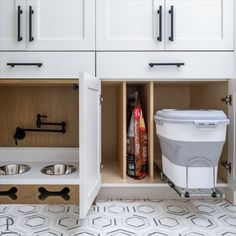 an open cabinet in the kitchen with bowls and food