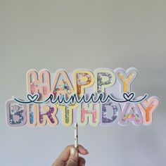 a person holding up a happy birthday card