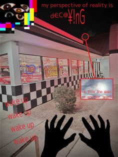 someone's hands reaching out to touch the ground in front of a building with posters on it