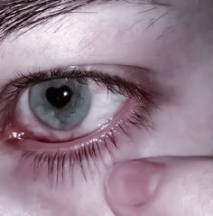 an extreme close up of a person's eye with water on the iris and part of their left eye visible