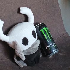 a stuffed animal with a can of monster energy on it's back and head