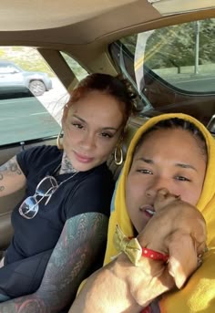 two people sitting in the back seat of a car with tattoos on their arms and legs