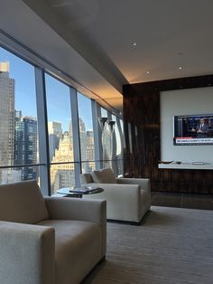a living room filled with furniture and tall windows