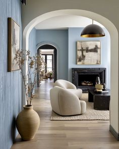 a living room filled with furniture and a fire place next to a wall mounted fireplace