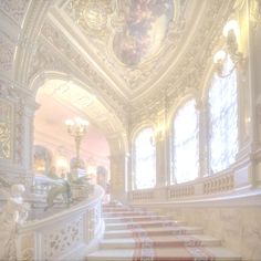 an ornately decorated staircase leads up to the second floor in this palace like building