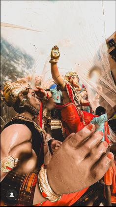 a group of people standing around each other with hands in the air and water pouring from their mouths