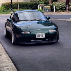 a green sports car is parked on the street