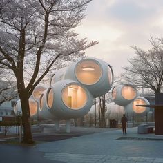 a person standing in front of a building with round lights on it's sides