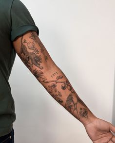 a man holding his arm with tattoos on it