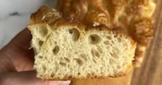 a person holding a piece of bread in their hand
